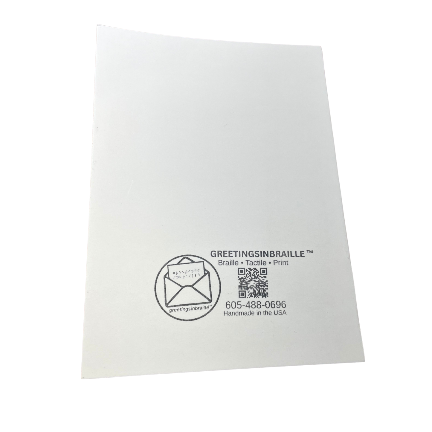 A white square paper card or envelope insert with black printed branding and text reading GREETINGSINBRAILLE, shown on a plain white background.