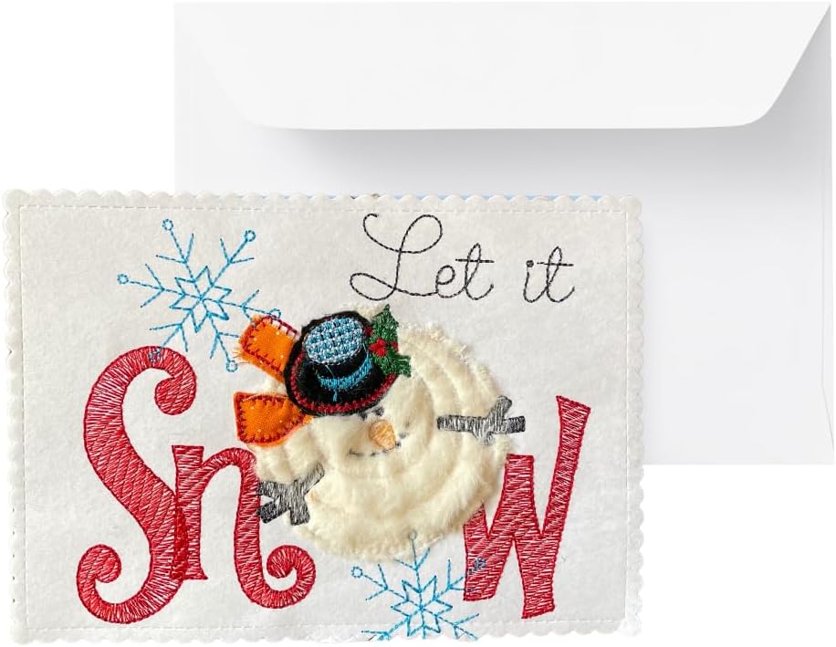 A square white embroidered greeting card with scalloped edges, featuring the phrase 'Let it Snow' in red and blue embroidery, with a raised 3D snowman wearing a black hat and orange scarf, shown in front of a white envelope.