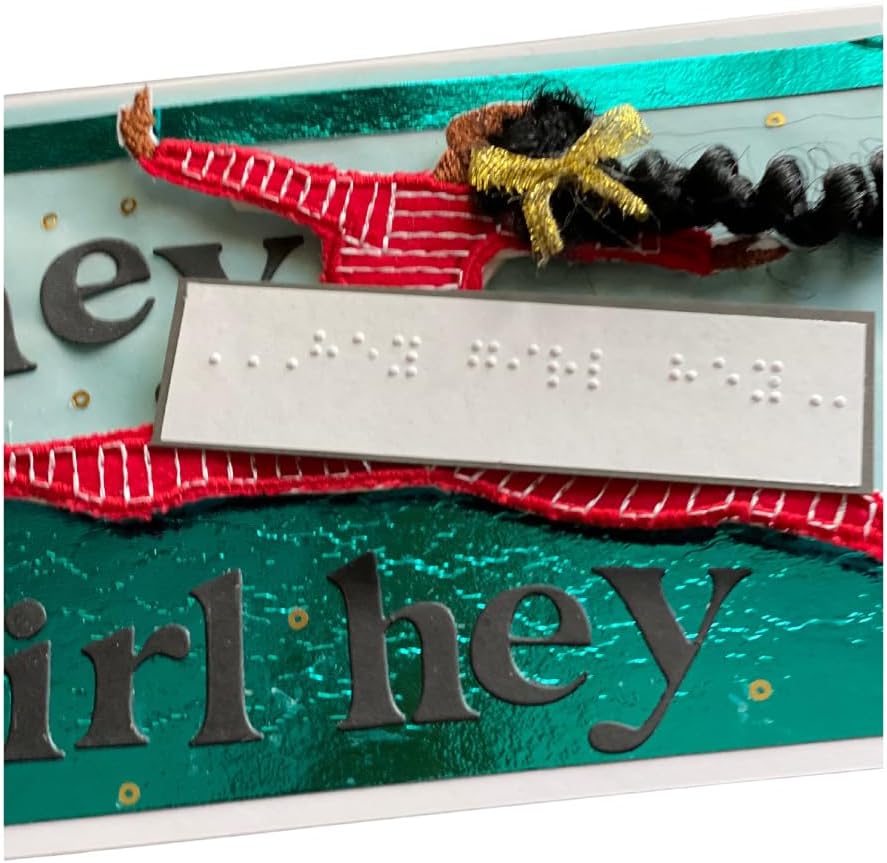 A close-up of a handmade greeting card or art piece featuring the phrase 'girl hey' in dark gray letters over a textured teal background, decorated with red and white striped ribbon, gold glitter, and a black-and-white braided hair piece with a gold bow.
