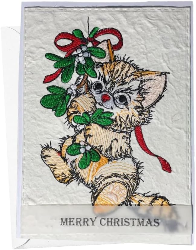 A square Christmas-themed patch or embroidered applique featuring a fluffy beige kitten holding green mistletoe with red ribbons, on a white textured background with 'MERRY CHRISTMAS' text at the bottom.