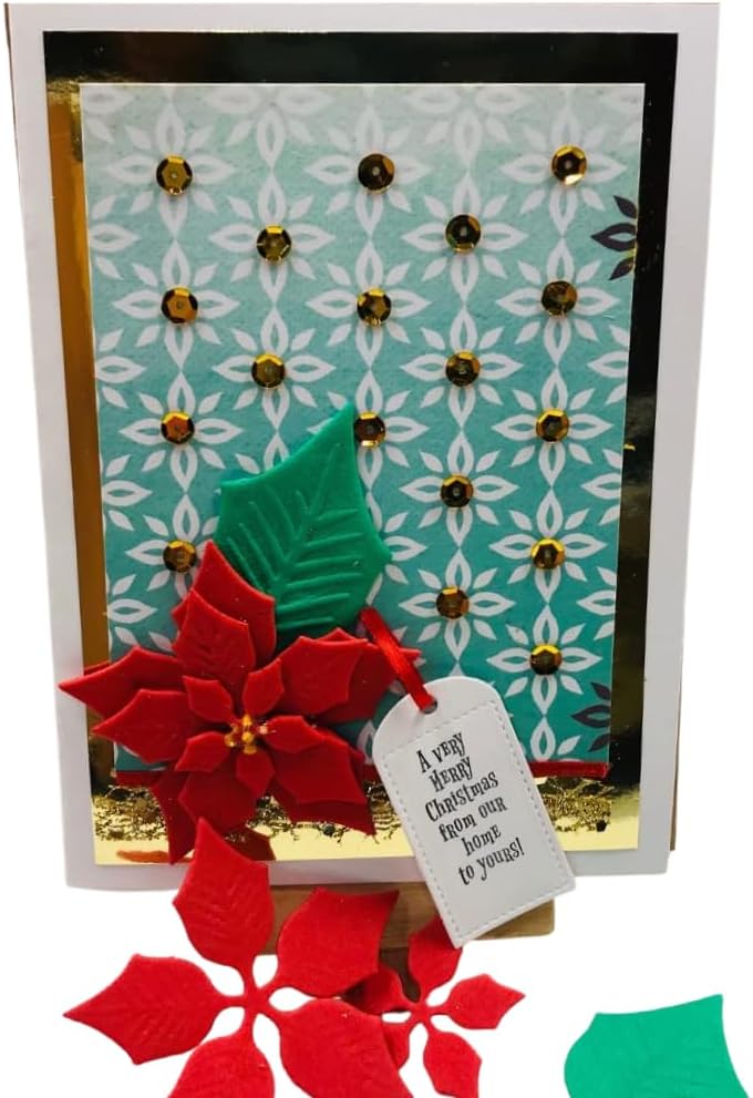 A handmade Christmas greeting card featuring a patterned aqua background with white floral motifs, gold rhinestone accents, a red felt poinsettia, a green felt leaf, and a small hanging tag that reads, 'A very happy Christmas then you know how much I love you!'.