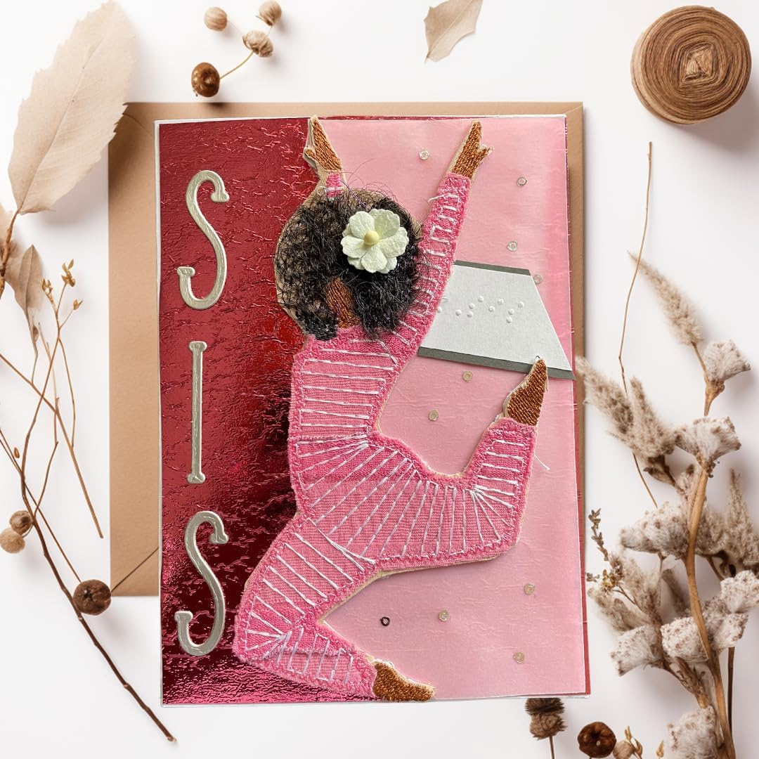 A handmade greeting card featuring a 3D cutout of a girl in a pink dance outfit with a white flower in her hair, set against a textured red and pink background with the letters 'SIS' in metallic silver. The card is displayed on a kraft envelope with dried botanicals on a white background.