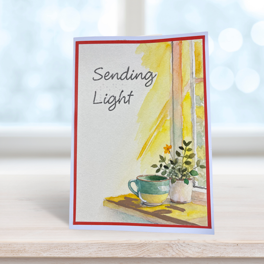 Card front in various display angles — watercolor window scene, teal mug, potted plant, red mat border