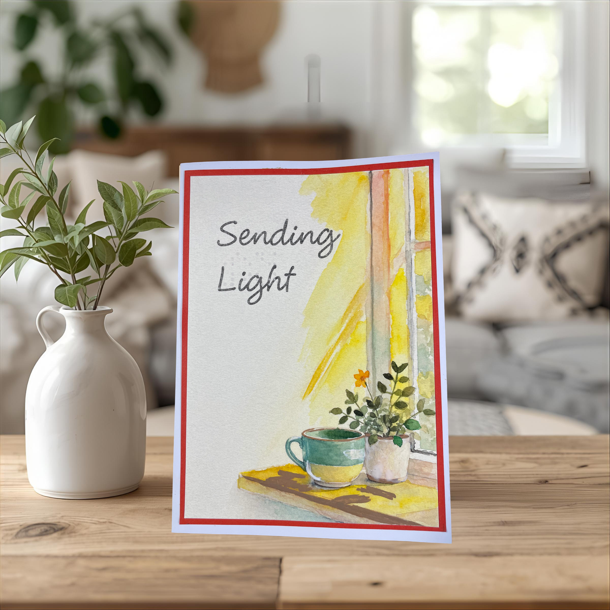  Propped on a wooden table beside a white vase with eucalyptus, cozy living room background