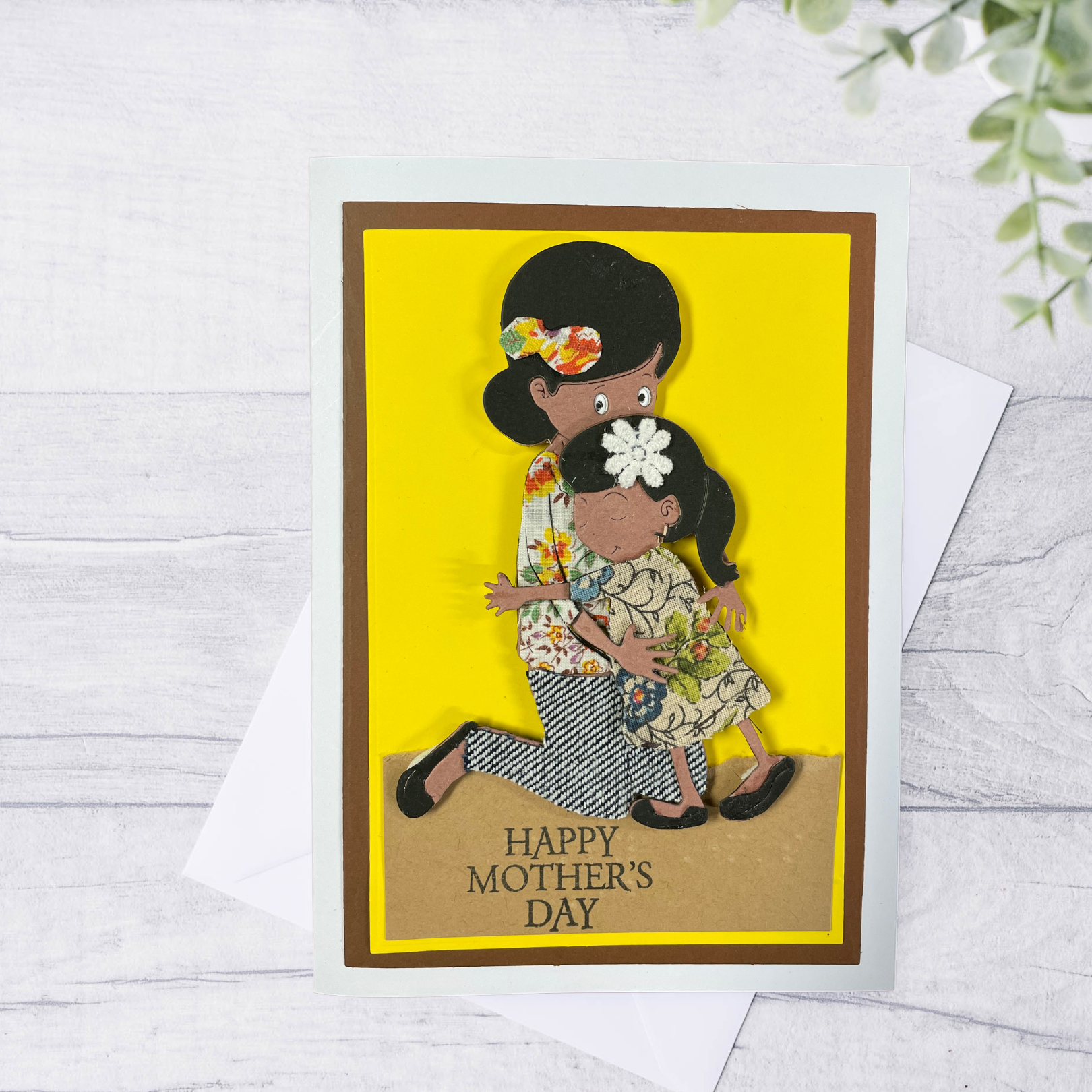 Mother's Day card with a tactile image of a mother and daughter on a yellow background