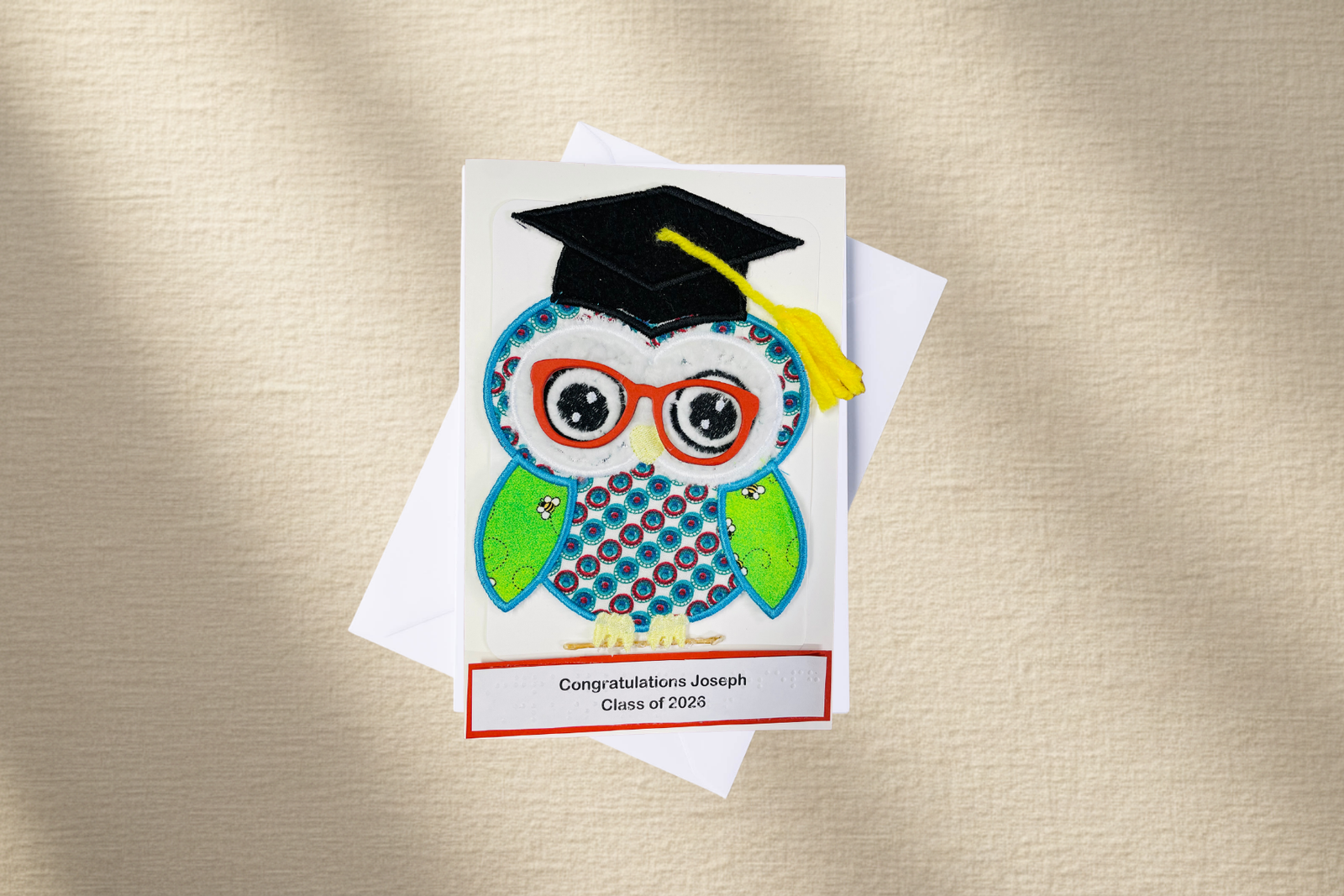 Graduation-themed card with an owl wearing a cap and tassel on a textured beige background
