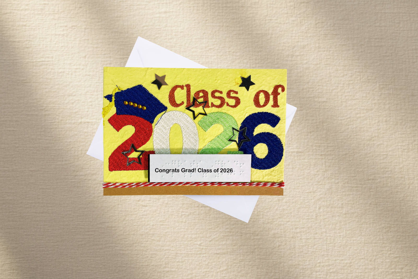 Graduation-themed card with 'Class of 2026' text on a textured beige background