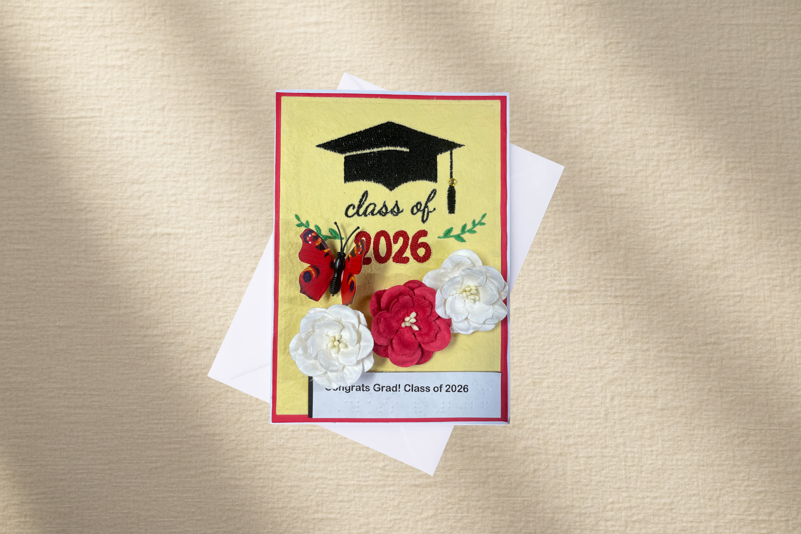 Graduation card with flowers and 'class of 2026' text on a textured gold background