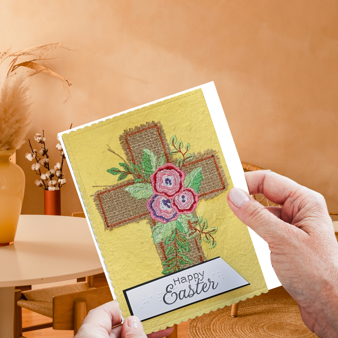 Hand holding a 'Happy Easter' card with floral cross design on a warm-toned background