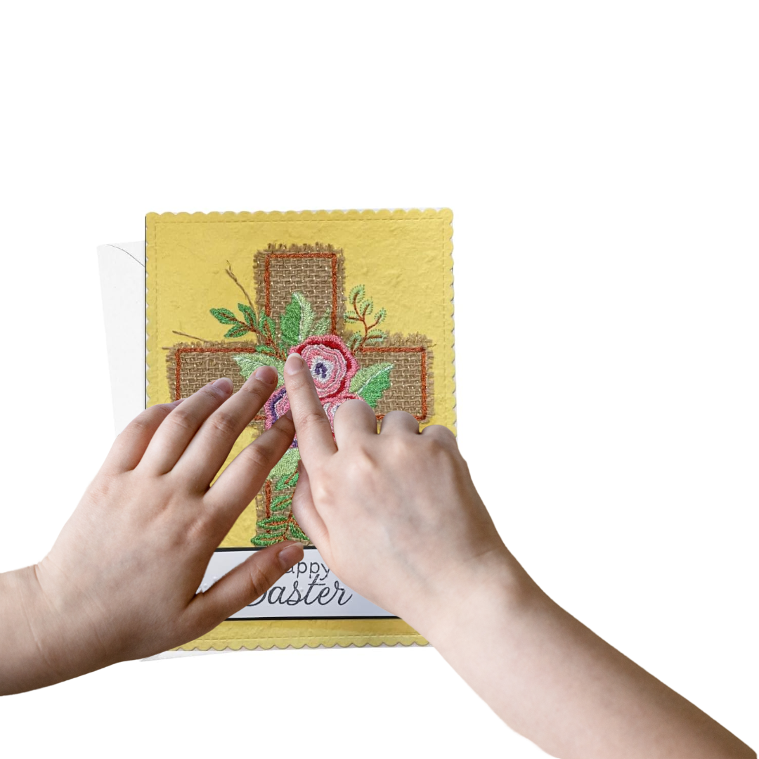 Two hands feeling the texture of  a yellow Easter card with floral cross design