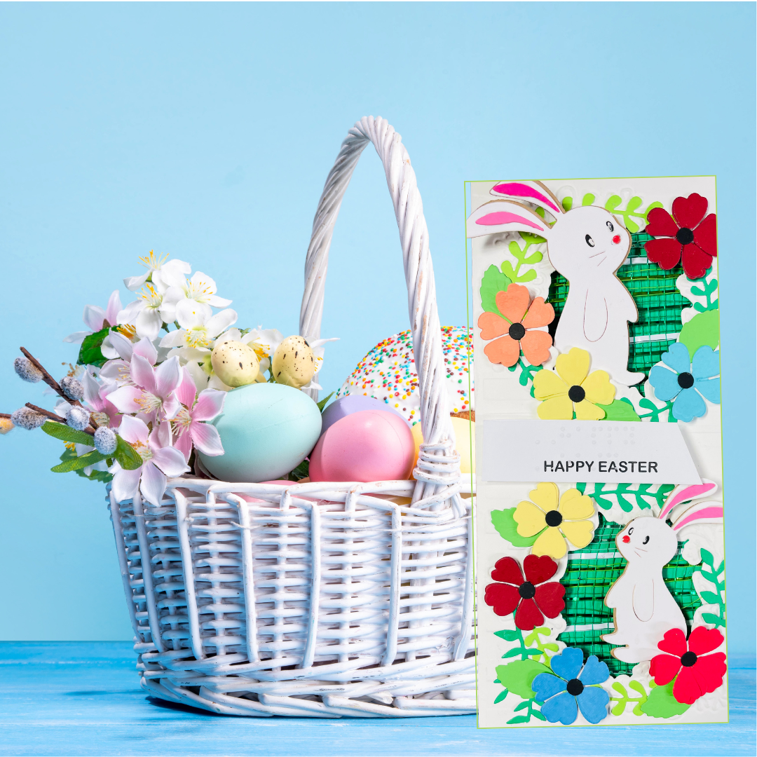 Easter basket with eggs and flowers next to a colorful 'Happy Easter' card on a blue background