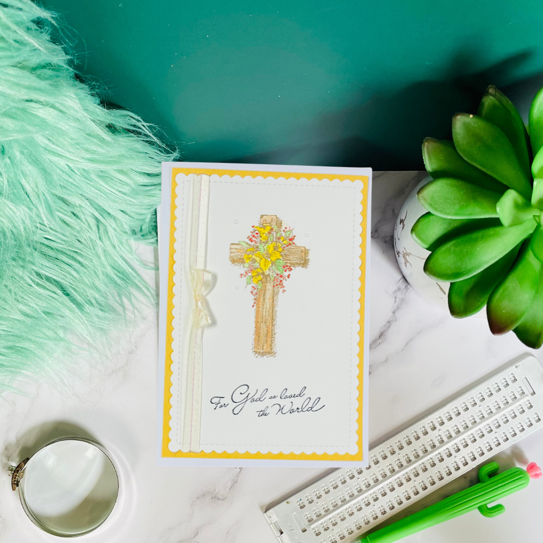Greeting card with cross design on a marble surface with decorative items.