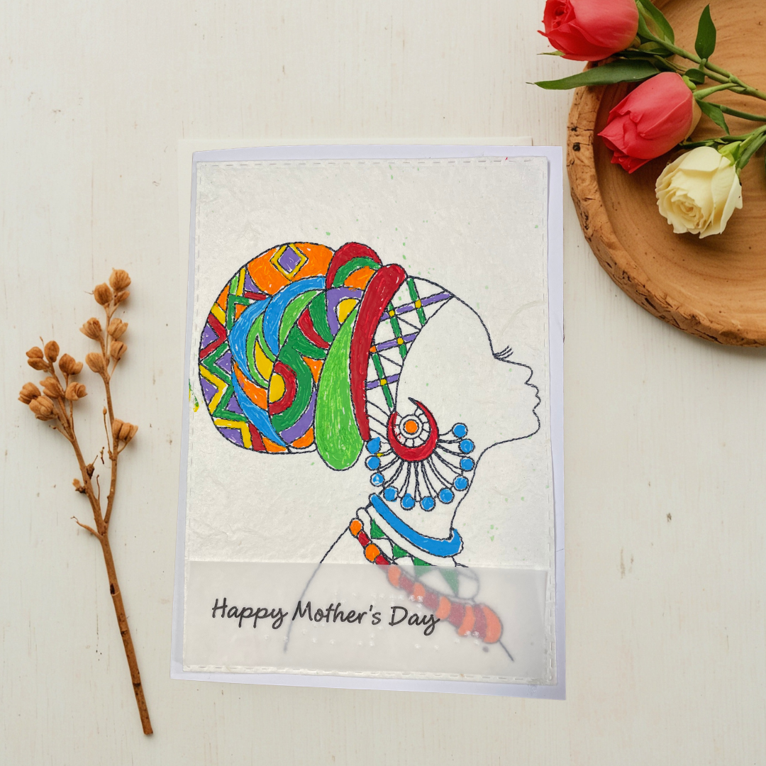 Mother's Day card features a hand-drawn profile silhouette of a woman adorned with a vivid geometric head wrap in orange, red, green, blue, and purple, paired with layered statement jewelry in matching jewel tone on a light surface with flowers and twigs.