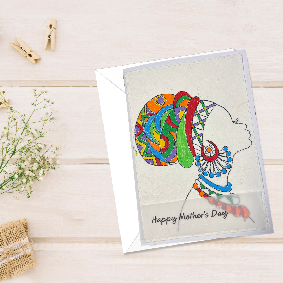 Mother's Day card features a hand-drawn profile silhouette of a woman adorned with a vivid geometric head wrap in orange, red, green, blue, and purple, paired with layered statement jewelry in matching jewel tone 'Happy Mother's Day' text on a wooden surface.