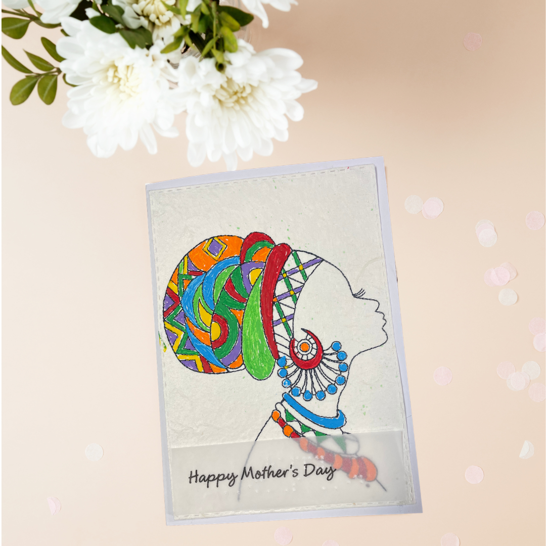 Mother's Day card features a hand-drawn profile silhouette of a woman adorned with a vivid geometric head wrap in orange, red, green, blue, and purple, paired with layered statement jewelry in matching jewel tone 'Happy Mother's Day' text, placed on a beige surface with white flowers.