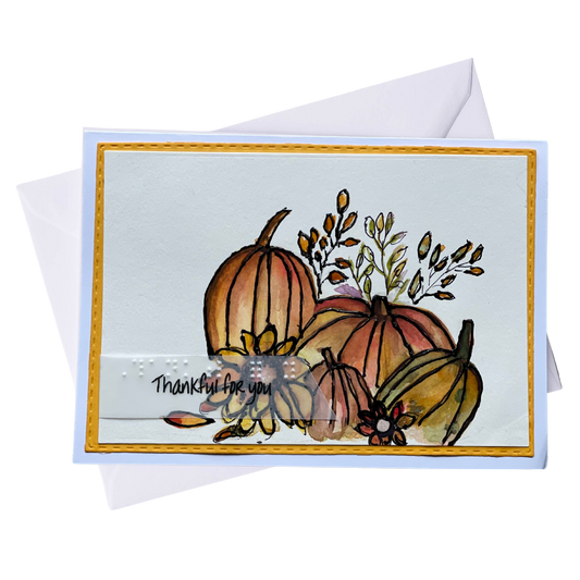 Handmade Thanksgiving greeting card with watercolor pumpkins and fall leaves.