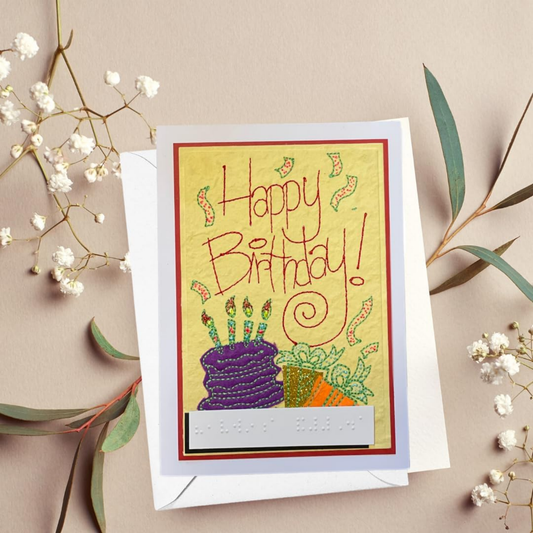 Emboirdery Birthday card with colorful cake illustration and 'Happy Birthday!' text on a beige background with flowers.