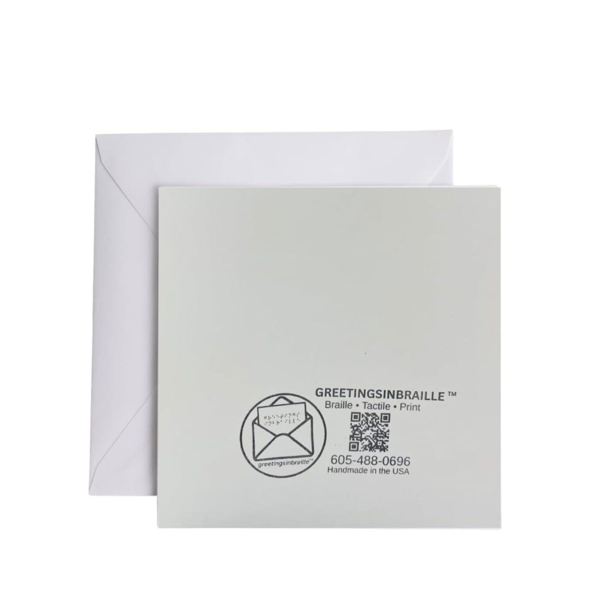 A square white greeting card with a printed black logo and text reading 'GREETINGSINBRAILLE' and a QR code, shown in front of a white envelope on a light gray background.