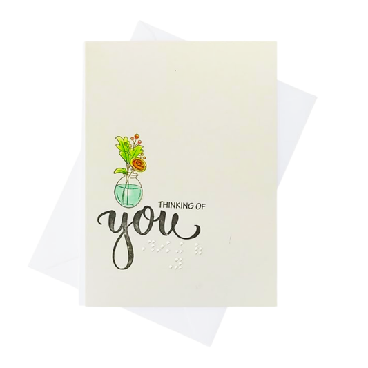 A greeting card with a watercolor illustration of flowers in a glass vase and the words 'THINKING OF you' in black script and braille 